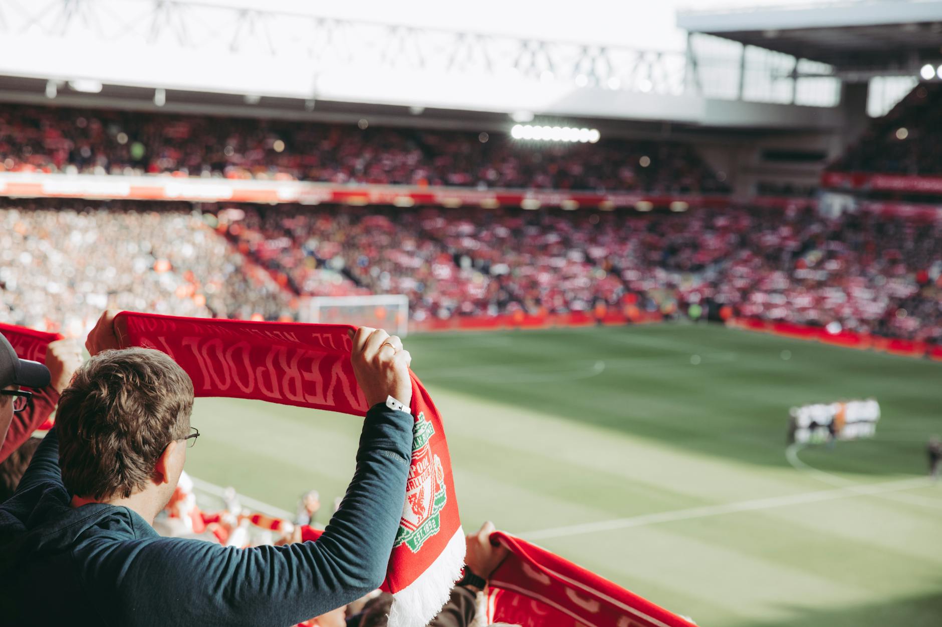 Liverpool Galatasaray 4-0 — Passionate soccer supporters with scarves in Anfield Stadium, capturing the thrill of the game.