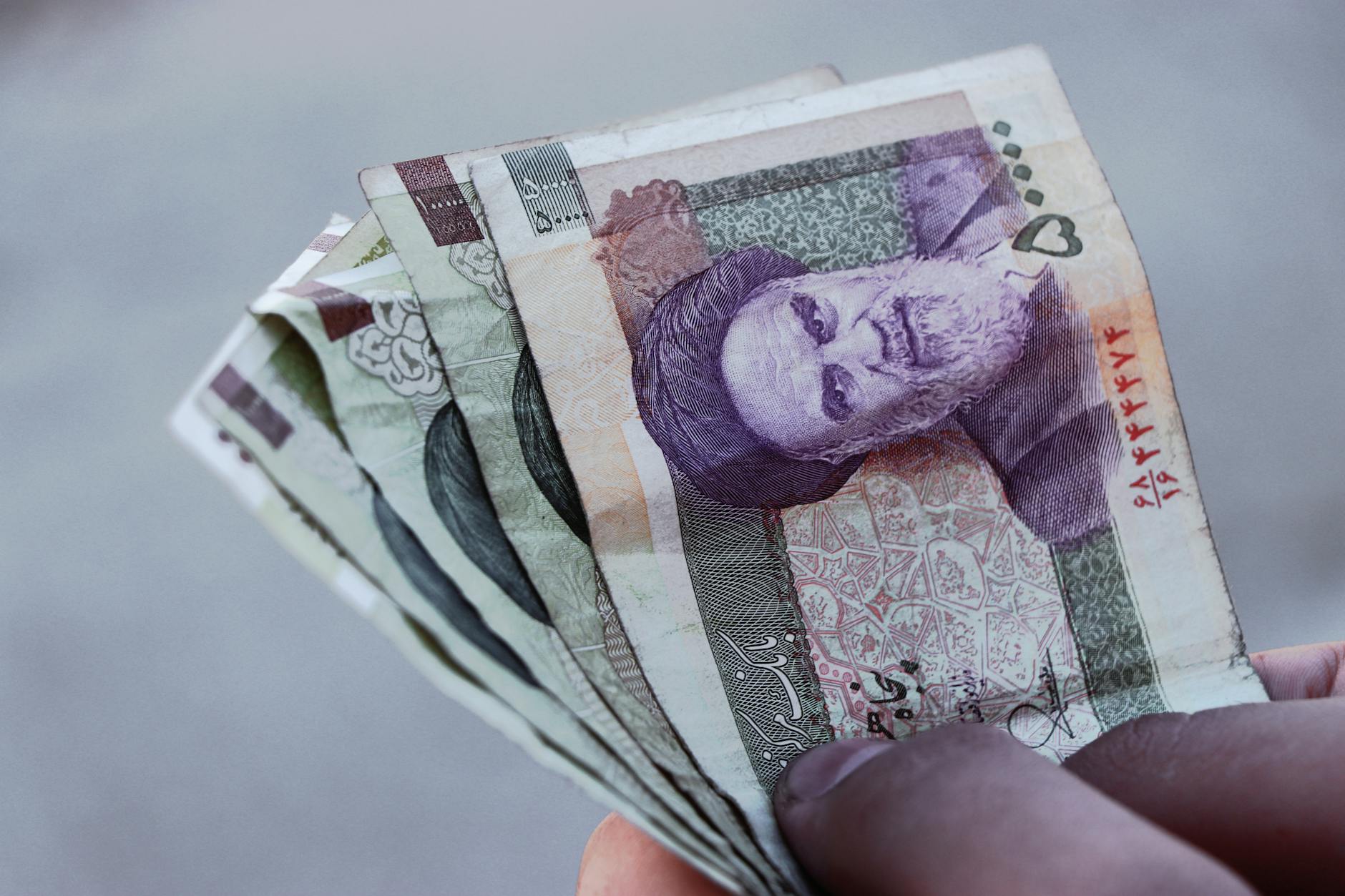 banconota da 10 milioni di rial — Detailed view of Iranian rial banknotes held in hand, illustrating finance and economy in Iran.