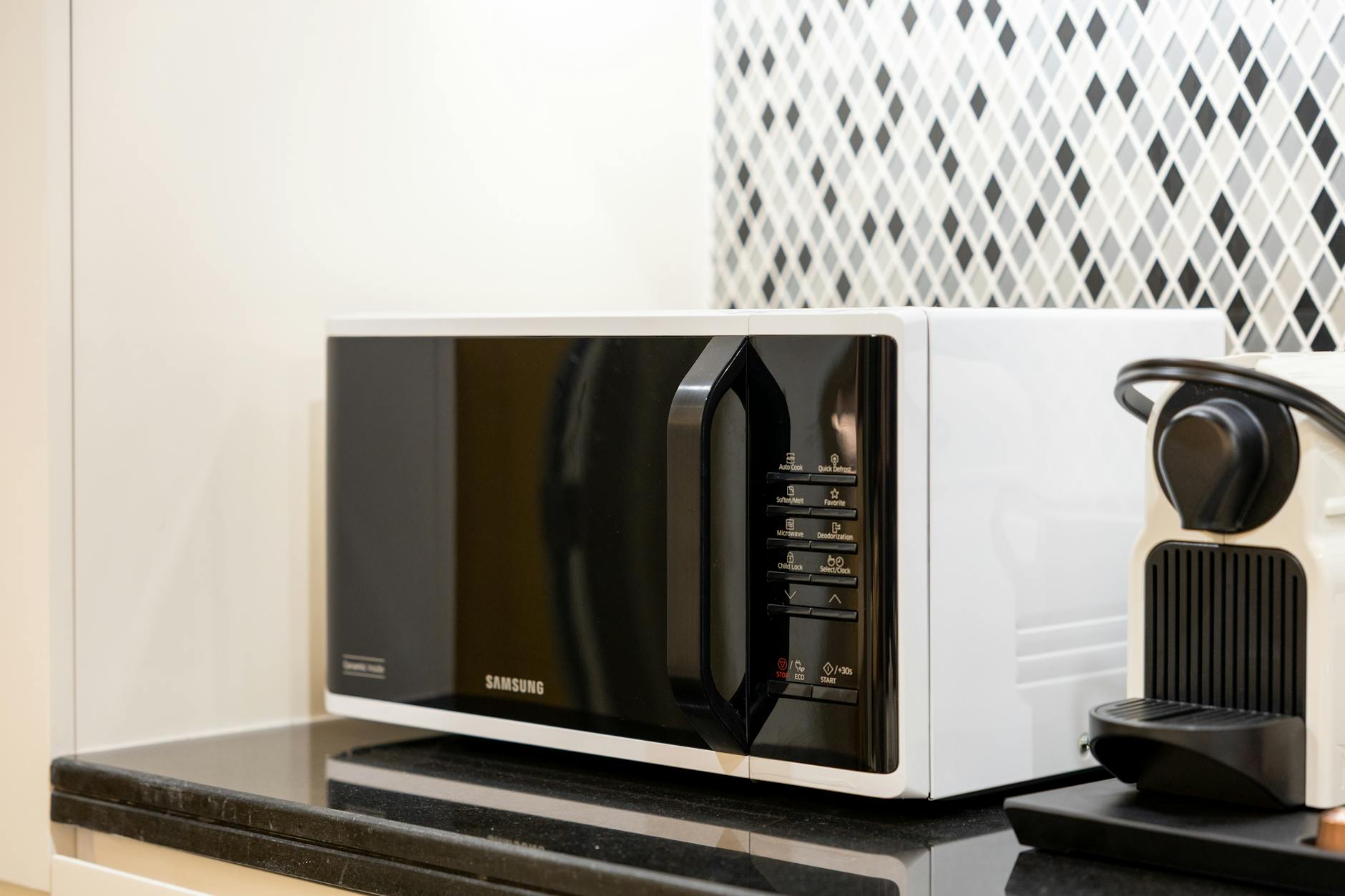 microonde multifunzione — Stylish kitchen setup featuring a black microwave and coffee maker on a counter.