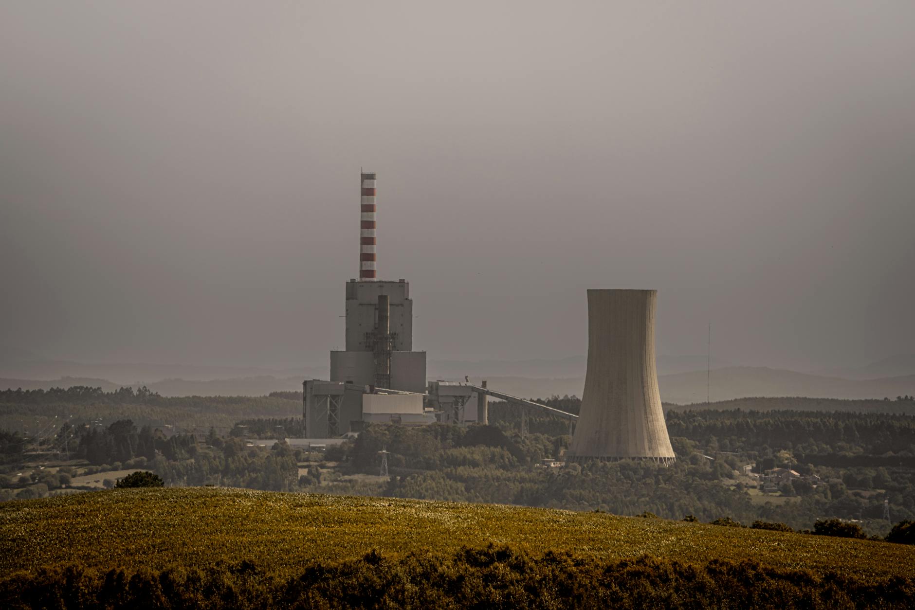 centrali a carbone — A coal-fired power plant emits smoke on an overcast day, highlighting energy and environmental issues.