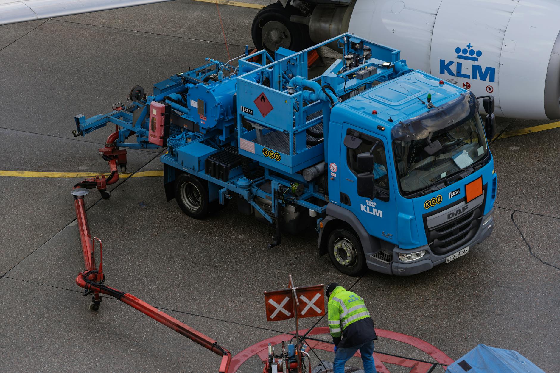 emergenza carburante aviazione — Ground crew at work refueling a KLM airplane with specialized equipment at an airport apron.