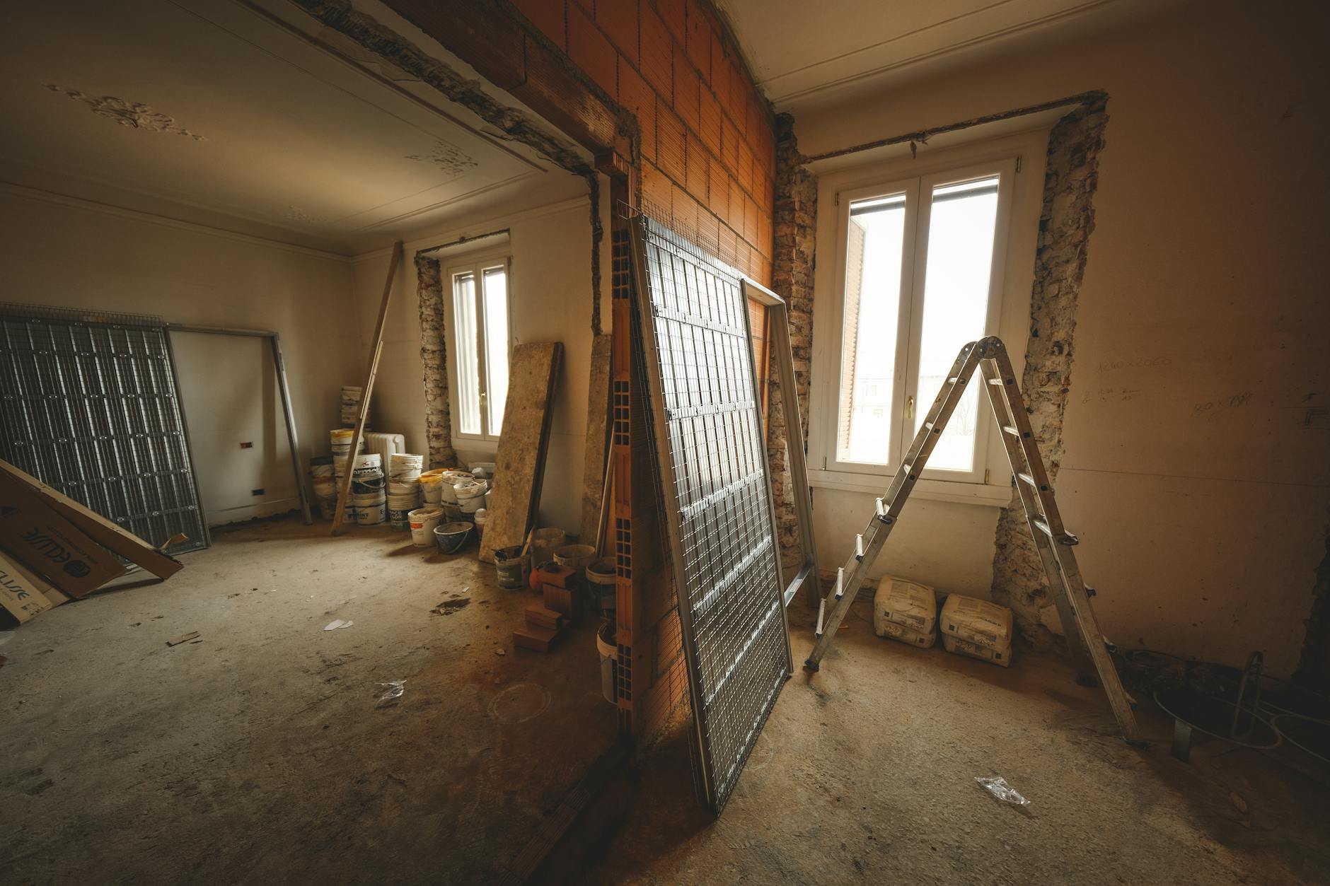 trasferimento detrazioni fiscali — Interior view of a room under renovation with construction materials and a ladder.