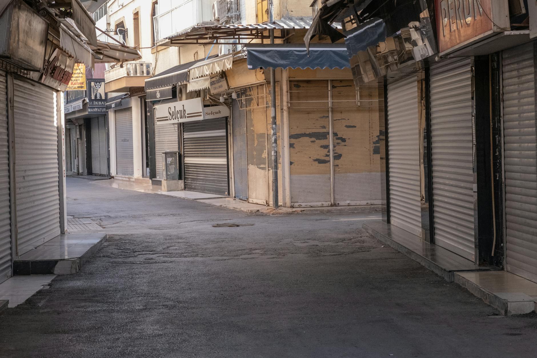 supermercati aperti Pasqua — A deserted street in İzmir, Türkiye, lined with closed shops and shuttered storefronts.