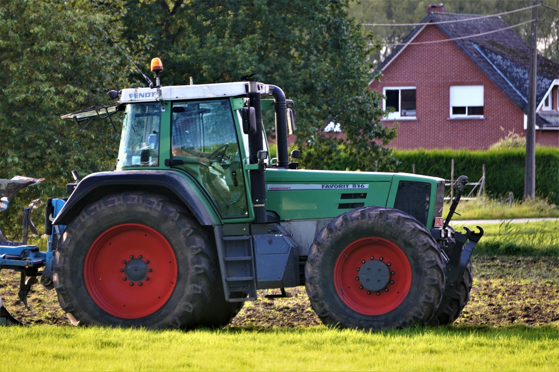 credito d'imposta gasolio agricolo — A vibrant tractor plowing a field, preparing for farming activities, with a rural backdrop.