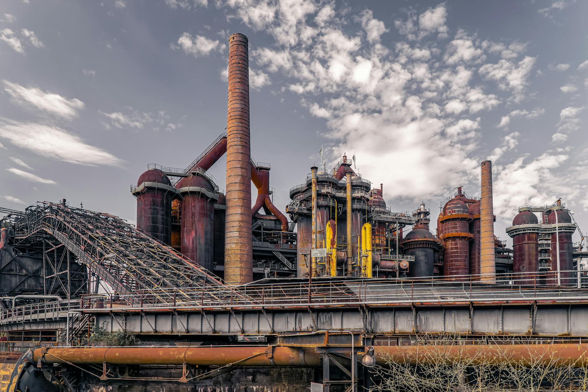cessione ex Ilva — Captivating image of a historic blast furnace with cloudy sky backdrop.