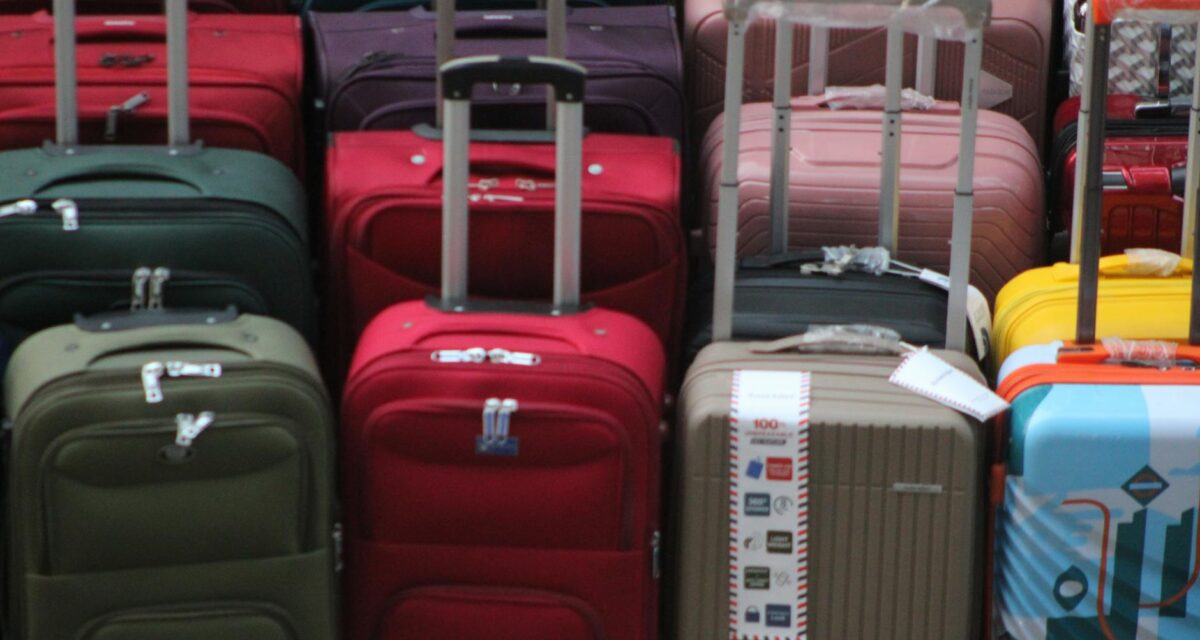 tariffe bagagli — A vibrant collection of various suitcases stacked in preparation for travel.