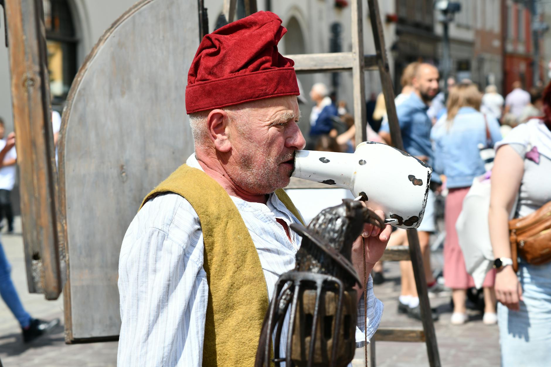 teatro di strada — A street performer dressed in traditional clothing captivates an audience with his act on a bustling city street.