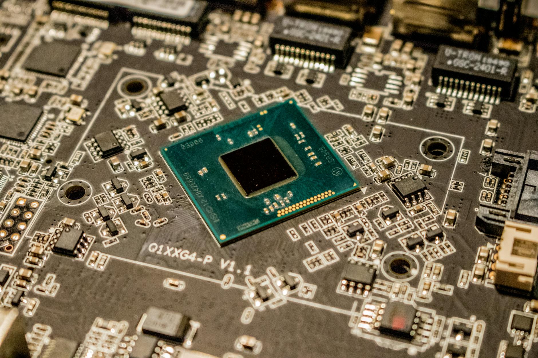 chip fotonici al grafene — Detailed view of a microchip on a printed circuit board, showcasing electronic components.