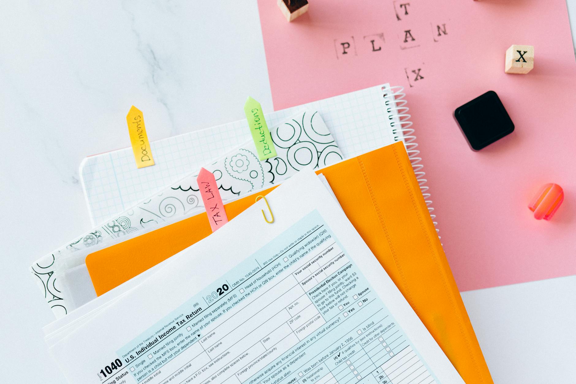 IMU 2026 — Overhead view of tax documents, forms, and organized work area for tax preparation.