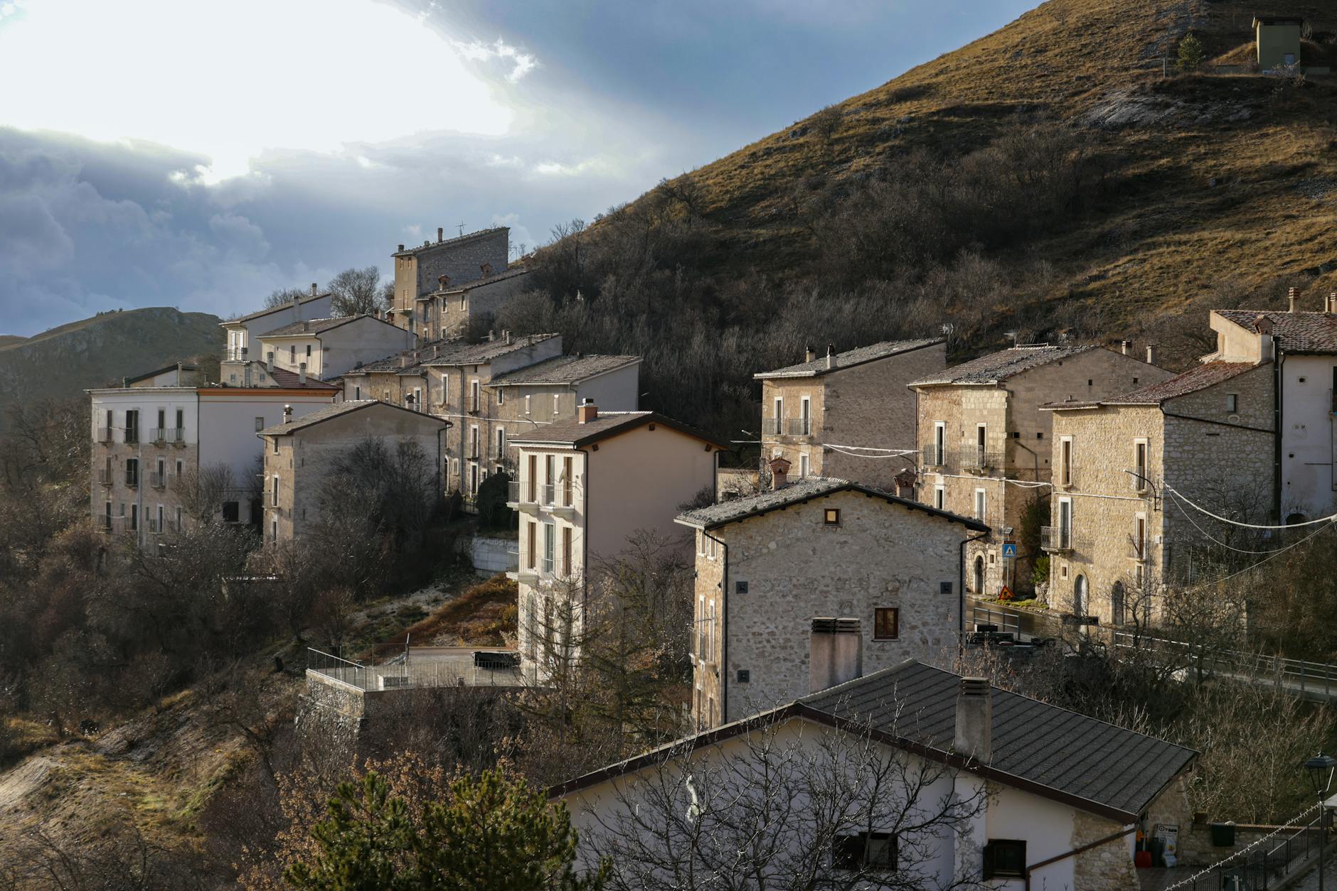rinascita borghi — Rustic Italian village houses nestled on a hillside during daylight.