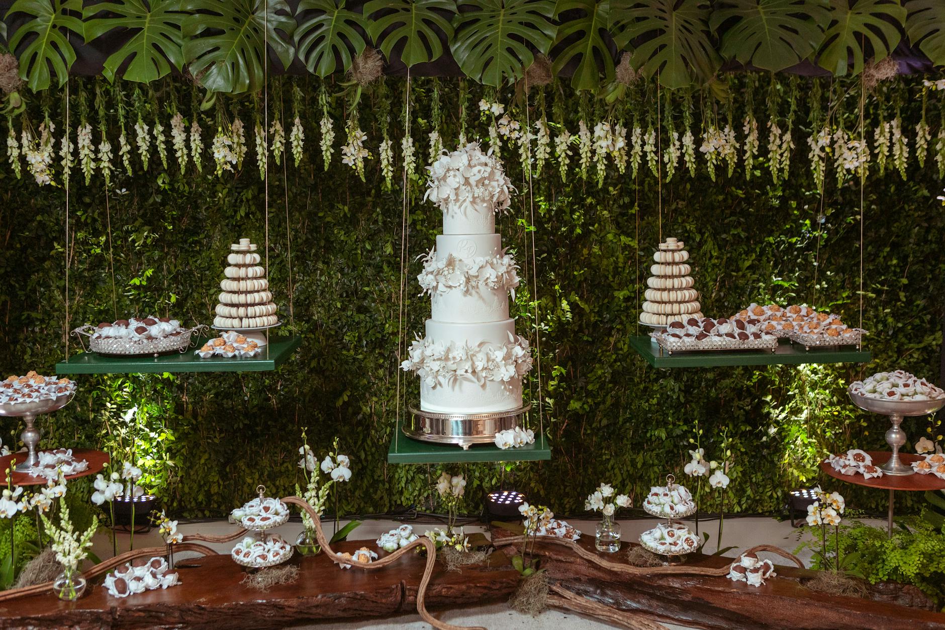torte nuziali d'élite — A beautifully decorated wedding dessert table featuring a grand floral cake and assorted sweets.