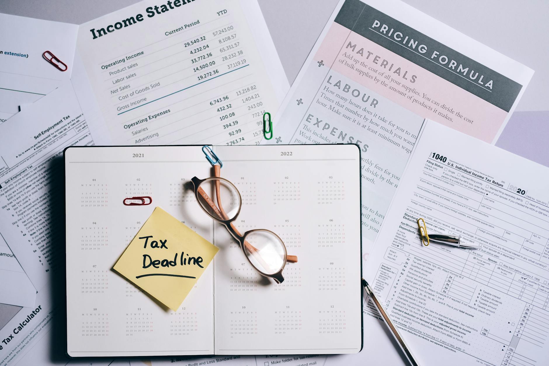 rottamazione cartelle — Overhead view of financial documents, planner, and glasses emphasizing tax deadline.