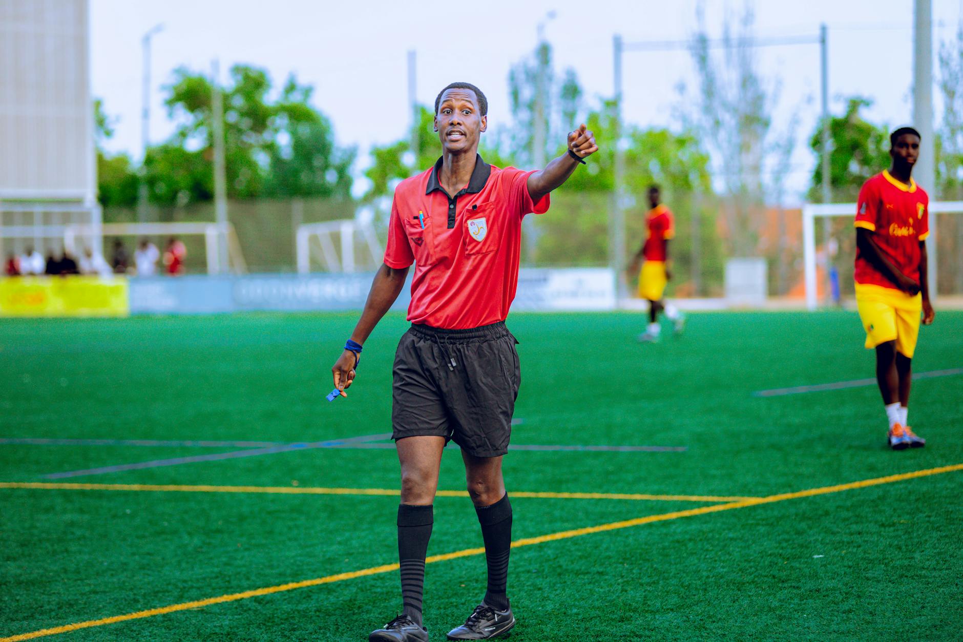 crisi FIGC — Referee in action during a football match, outdoors on a green field.