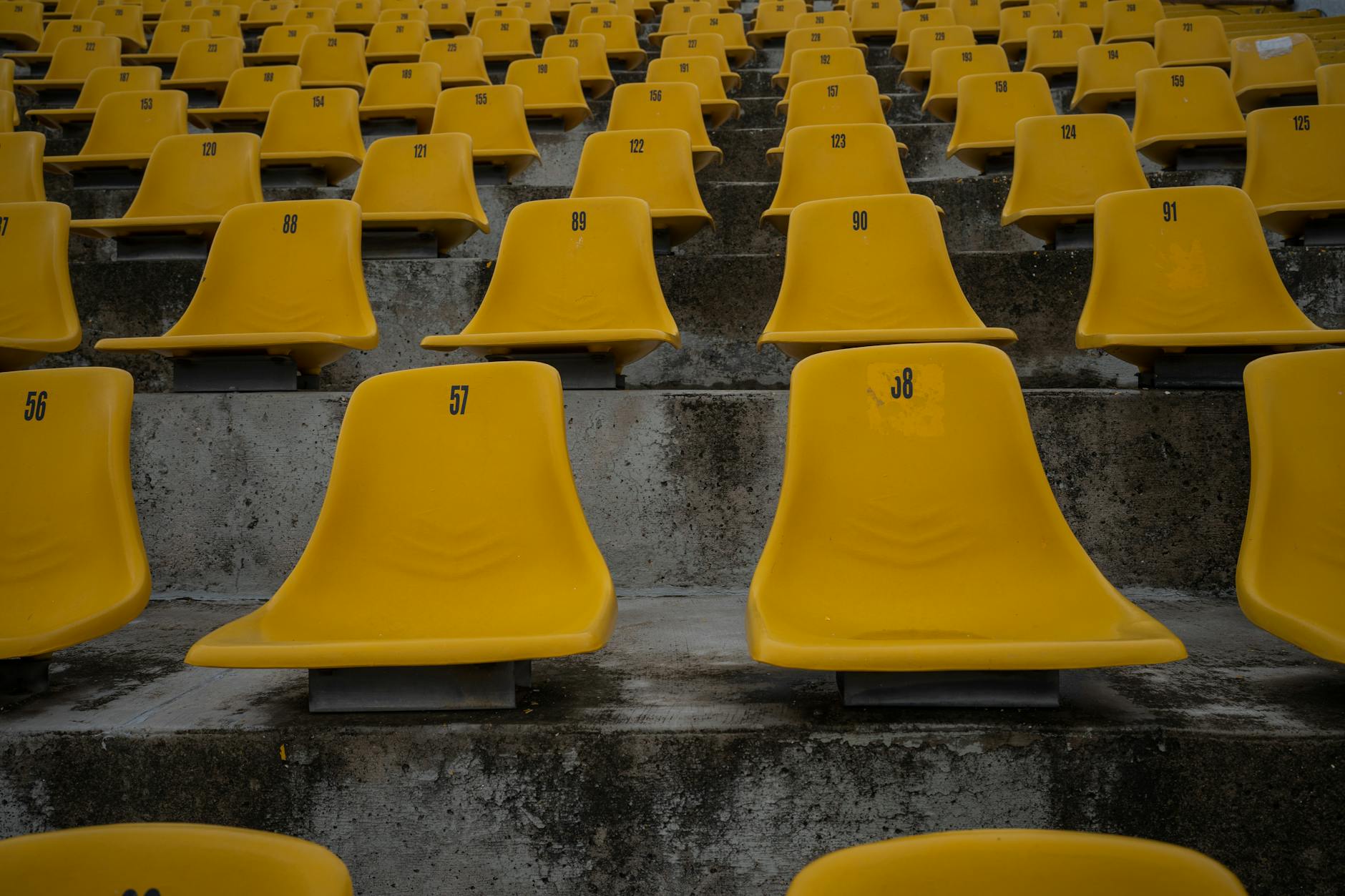 biglietti Mondiali 2026 — Rows of empty yellow stadium seats with numbered labels on concrete bleachers.