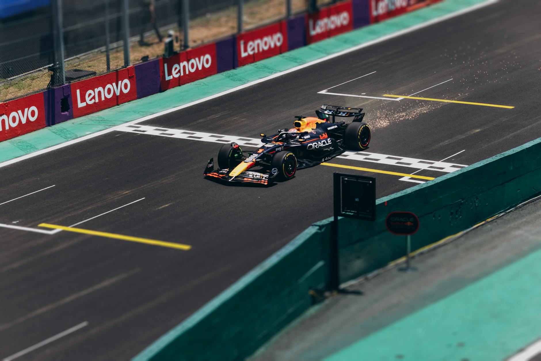 pole position sprint Miami — Formula 1 car speeding across the finish line on a racetrack, emitting sparks.