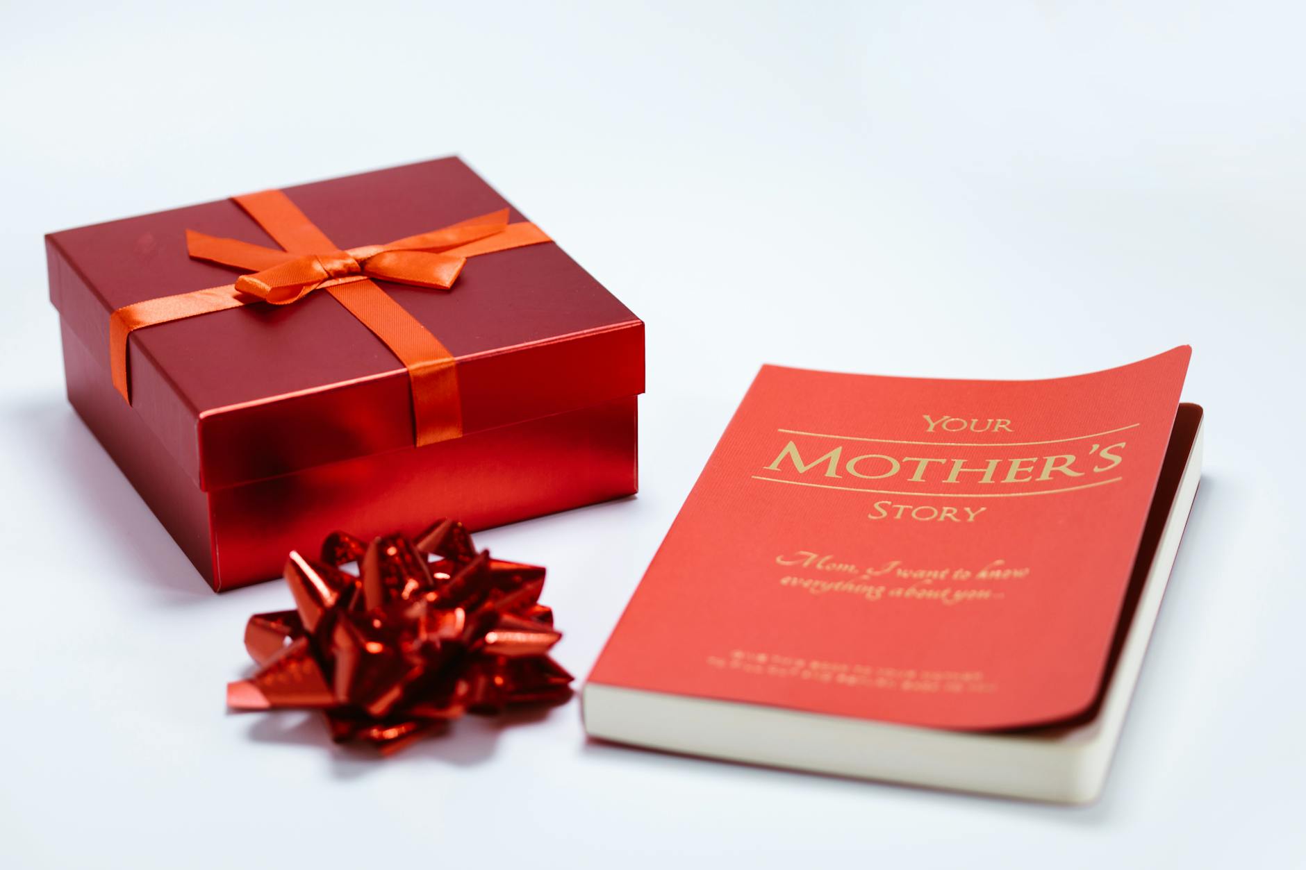 regali analogici — Red gift box and book "Your Mother's Story" ideal for Mother's Day gifting.