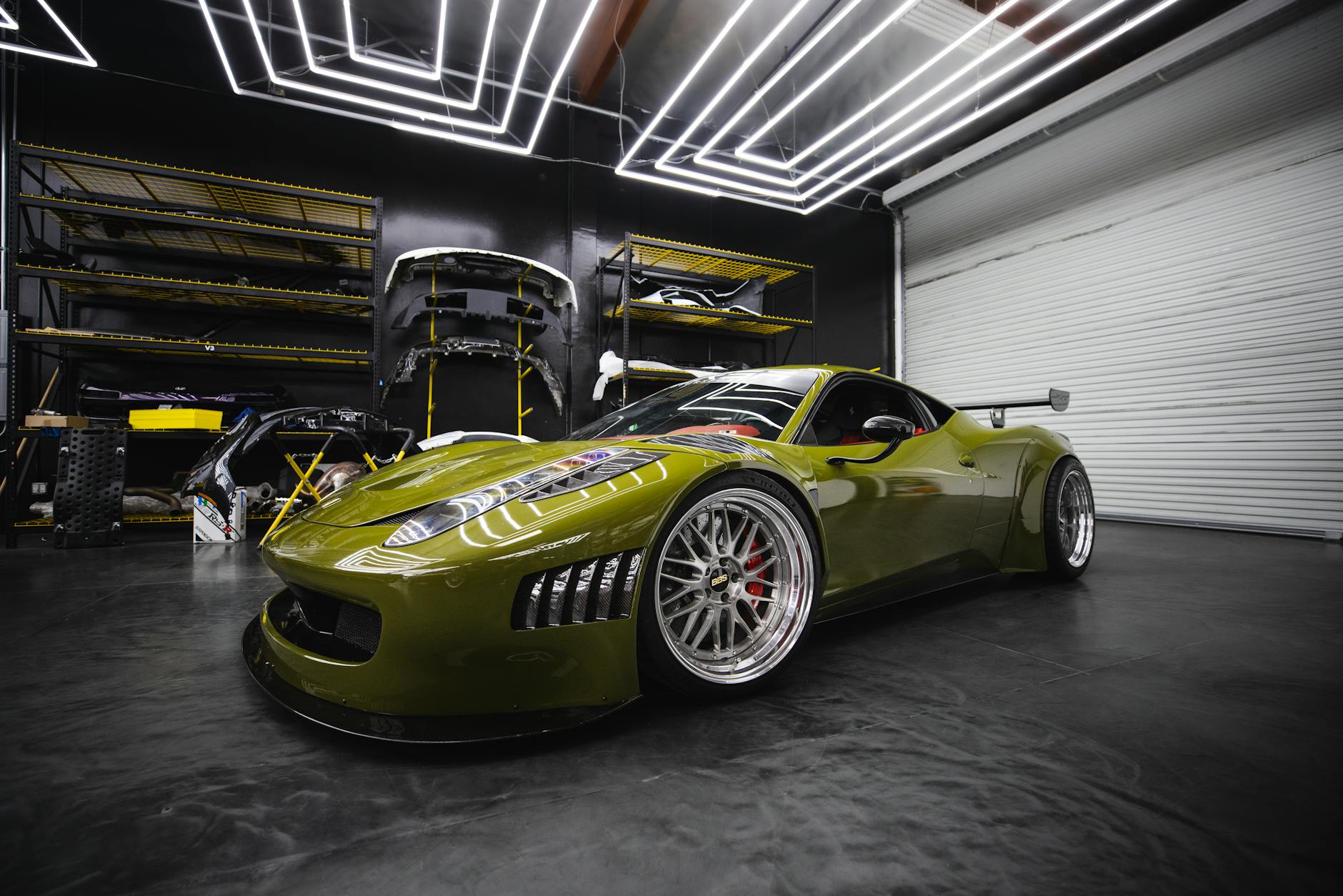 strategia aziendale Ares Atelier — A sleek green sports car with custom modifications in a modern garage workshop.