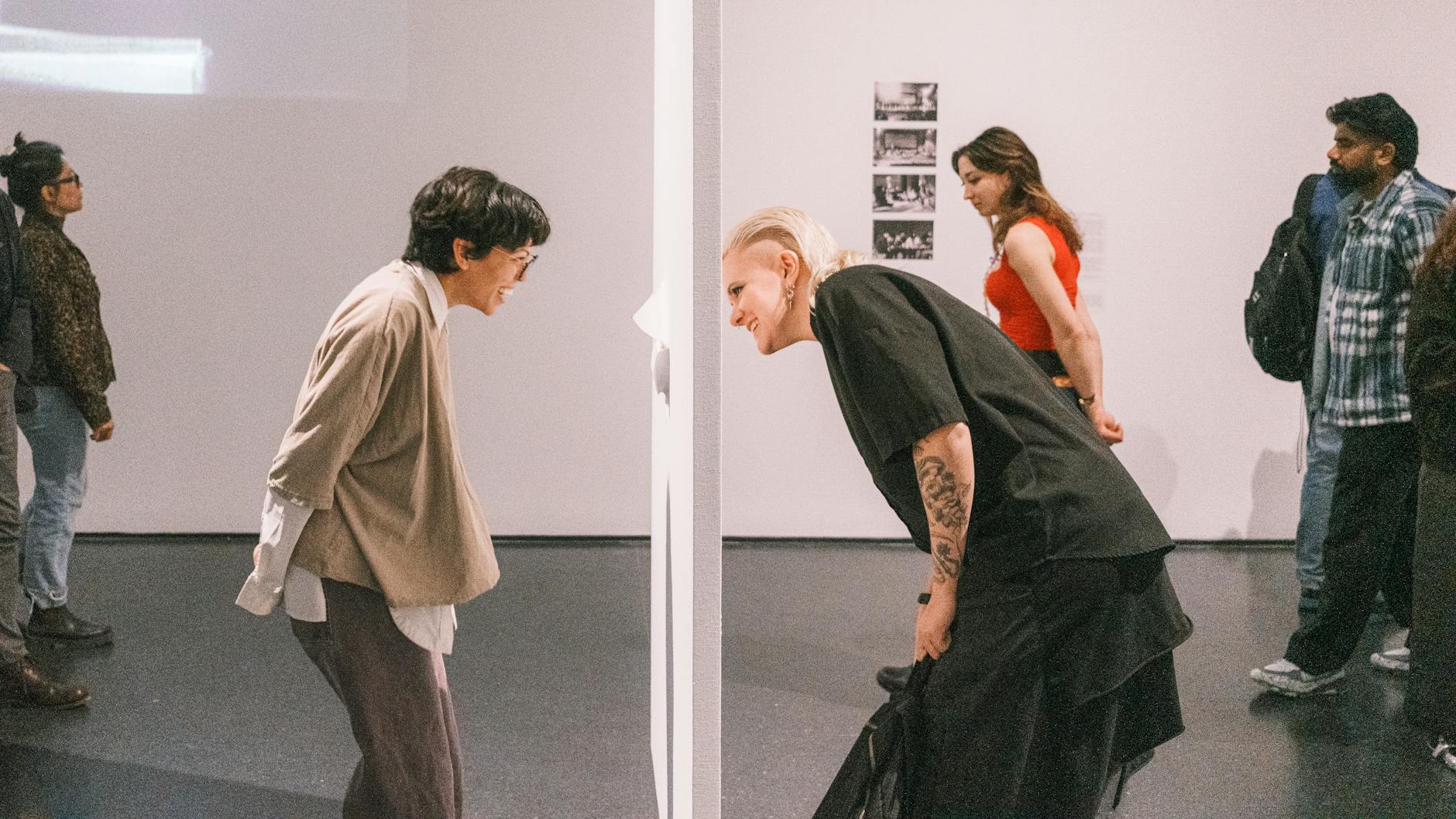 mostra Impressionismo successo — People engaging with art installation at an indoor exhibition.