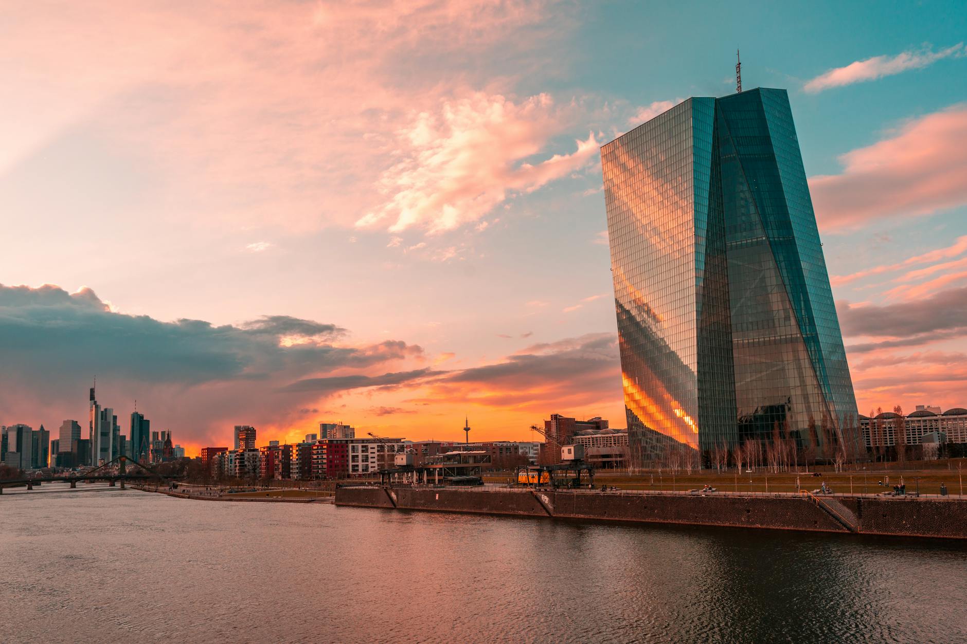 politica monetaria europea — Stunning sunset over Frankfurt's skyline featuring the iconic ECB Tower and Main River.