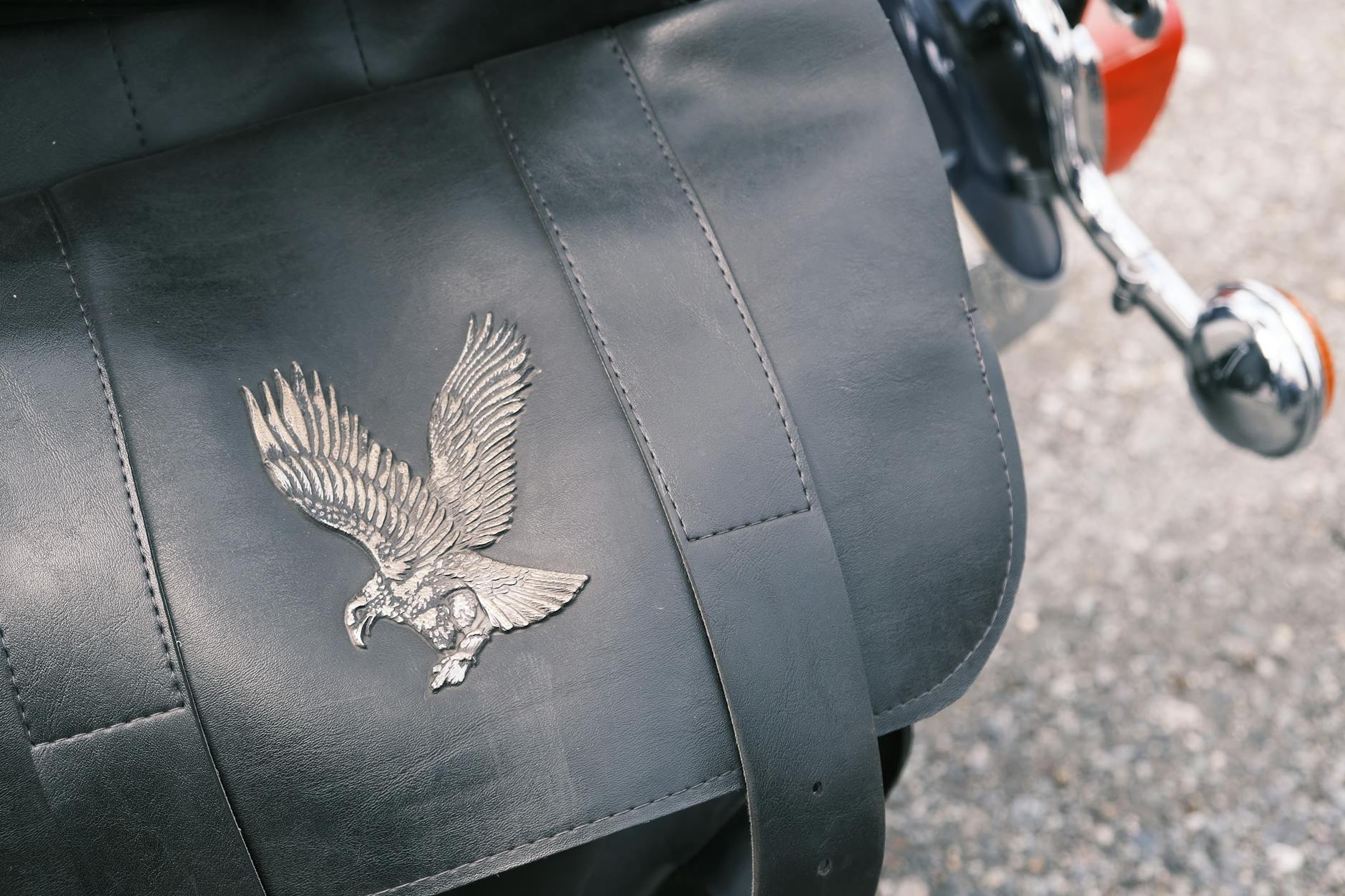 borse da motociclisti — Detailed close-up of a leather bag featuring an embossed eagle design, capturing a classic and stylish vibe.