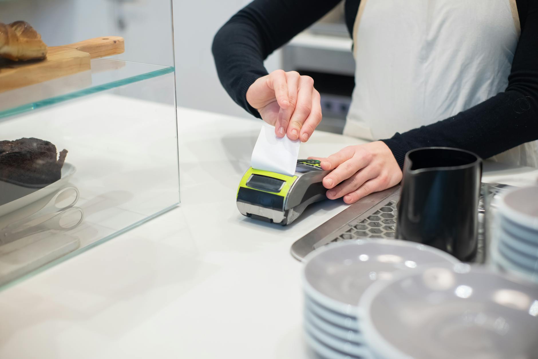 scontrini digitali — Close-up of a cashless transaction at a modern café counter with hands holding a receipt.