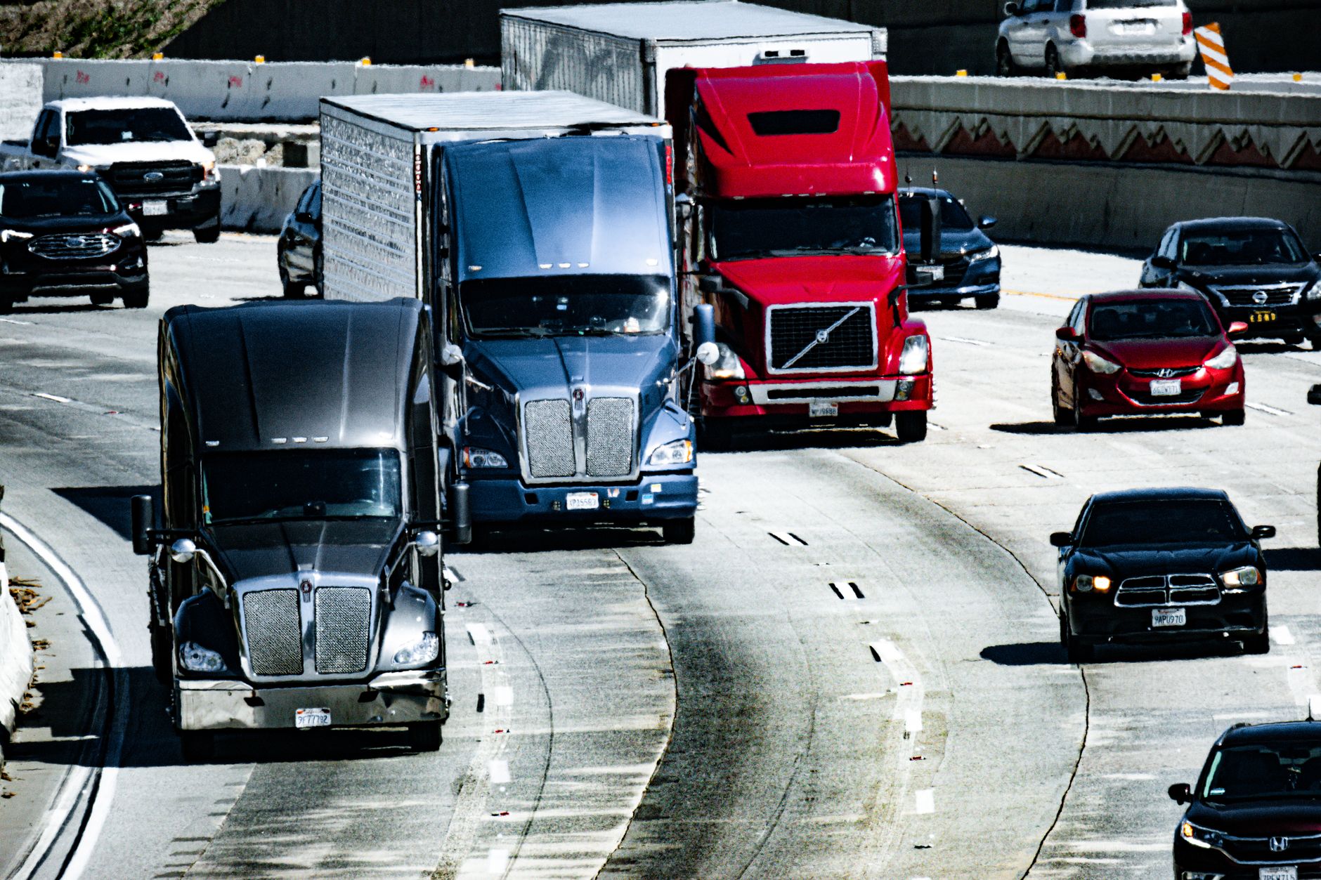 tecnologia agentica — Trucks and cars traveling on a congested city highway during the day.