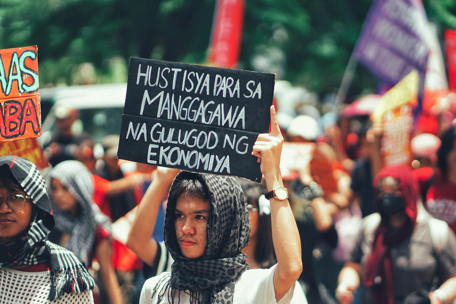 protesta Electrolux — Protesters gathered outdoors holding signs demanding economic justice and workers' rights.