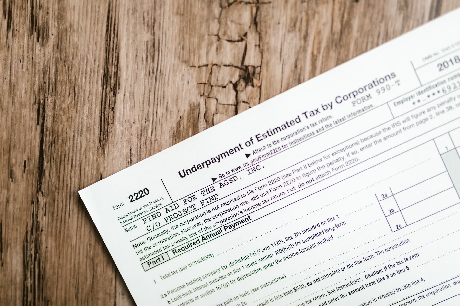 manovra fiscale 2026 — Close-up of a corporate tax form on a textured wooden surface, highlighting document details.