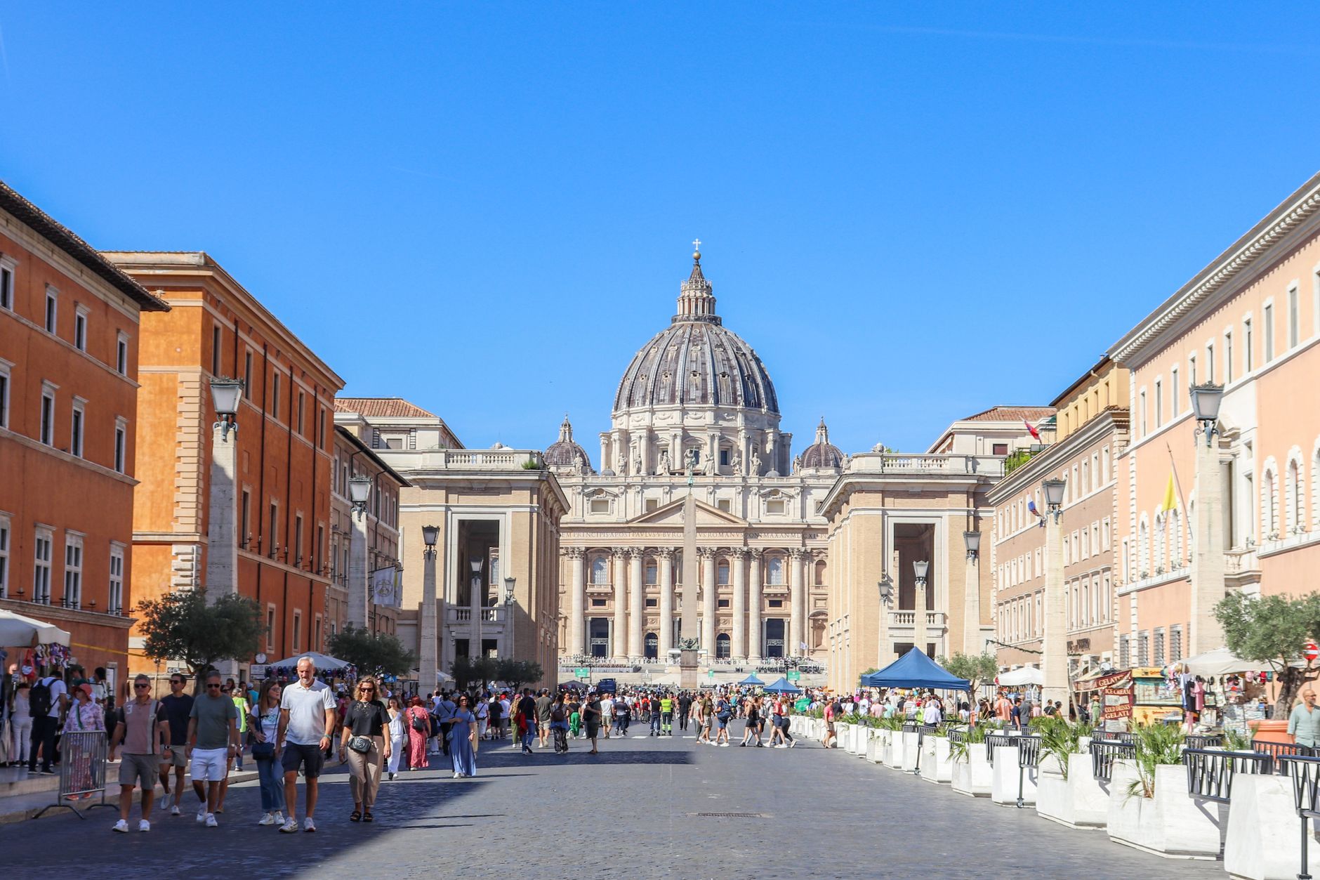 turismo Roma Giubileo — Busy street scene leading to St. Peter's Basilica in Vatican City on a bright and sunny day.
