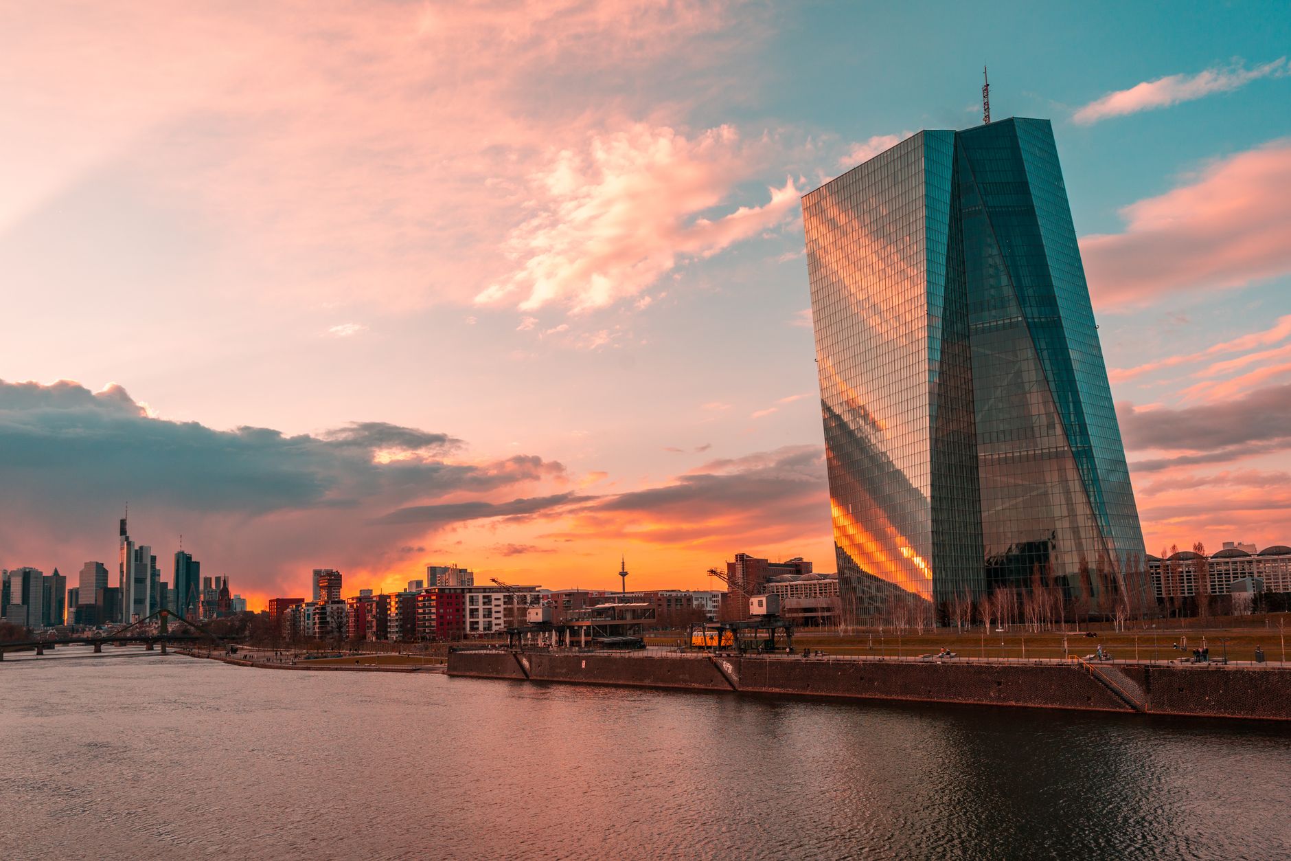 alzare i tassi BCE — Stunning sunset over Frankfurt's skyline featuring the iconic ECB Tower and Main River.