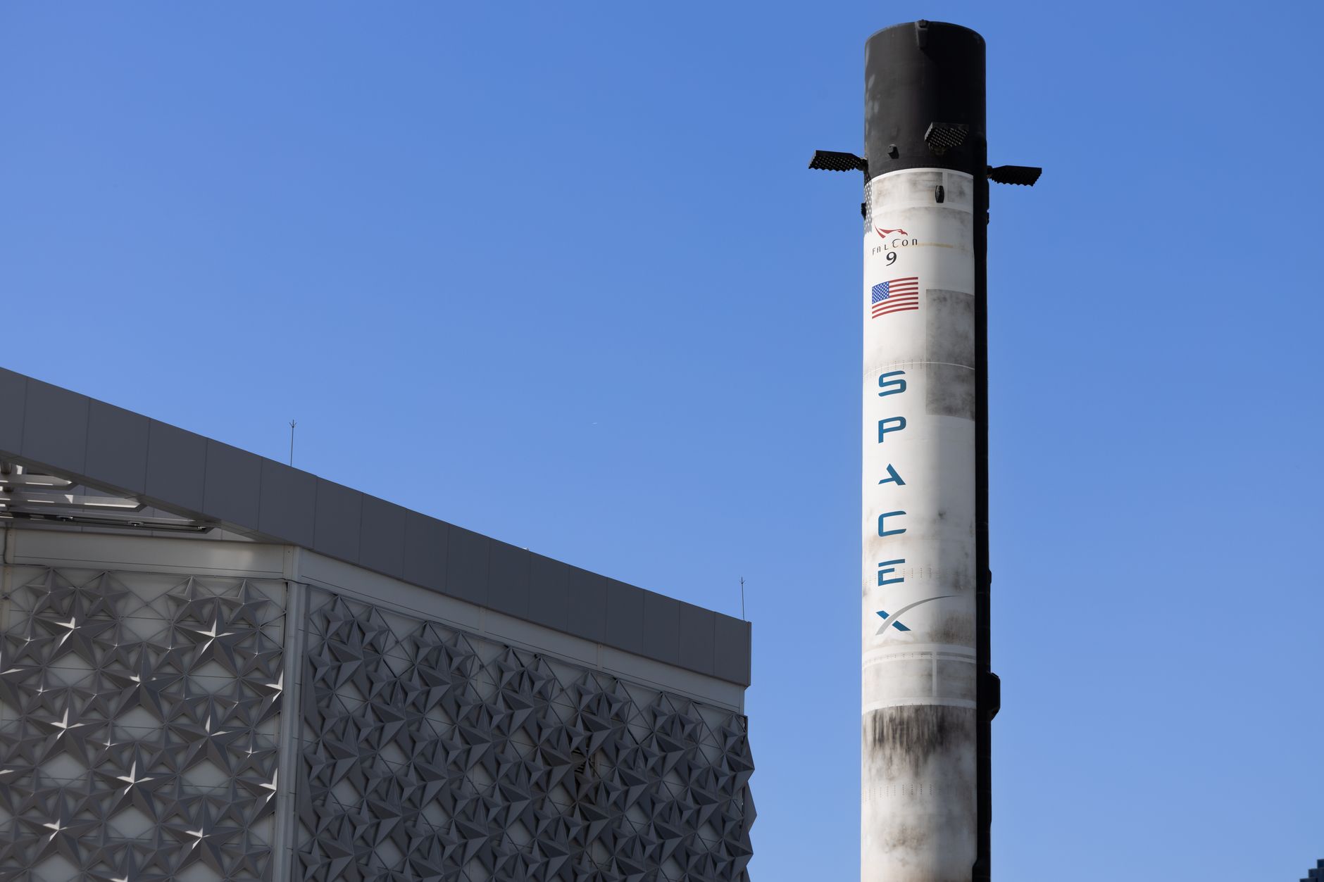 IPO di SpaceX — A SpaceX Falcon 9 rocket displayed outdoors against a clear blue sky in Dubai.