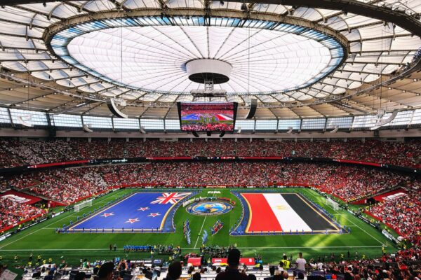 Wide-angle view of a soccer match with international flags at BC Place, Vancouver.