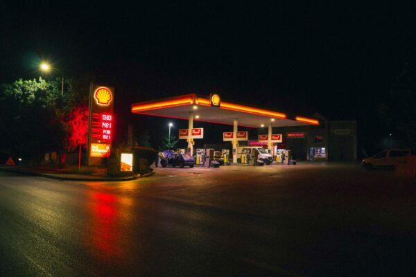 A gas station with glowing neon lights at night, showcasing a calm urban scene.