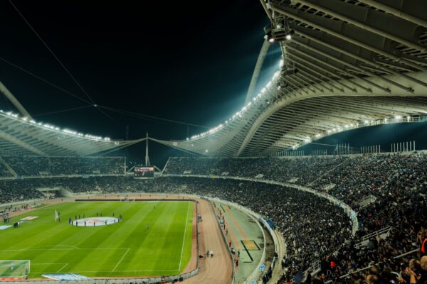 A crowded soccer stadium under bright lights at night, capturing the excitement of a live sports event.