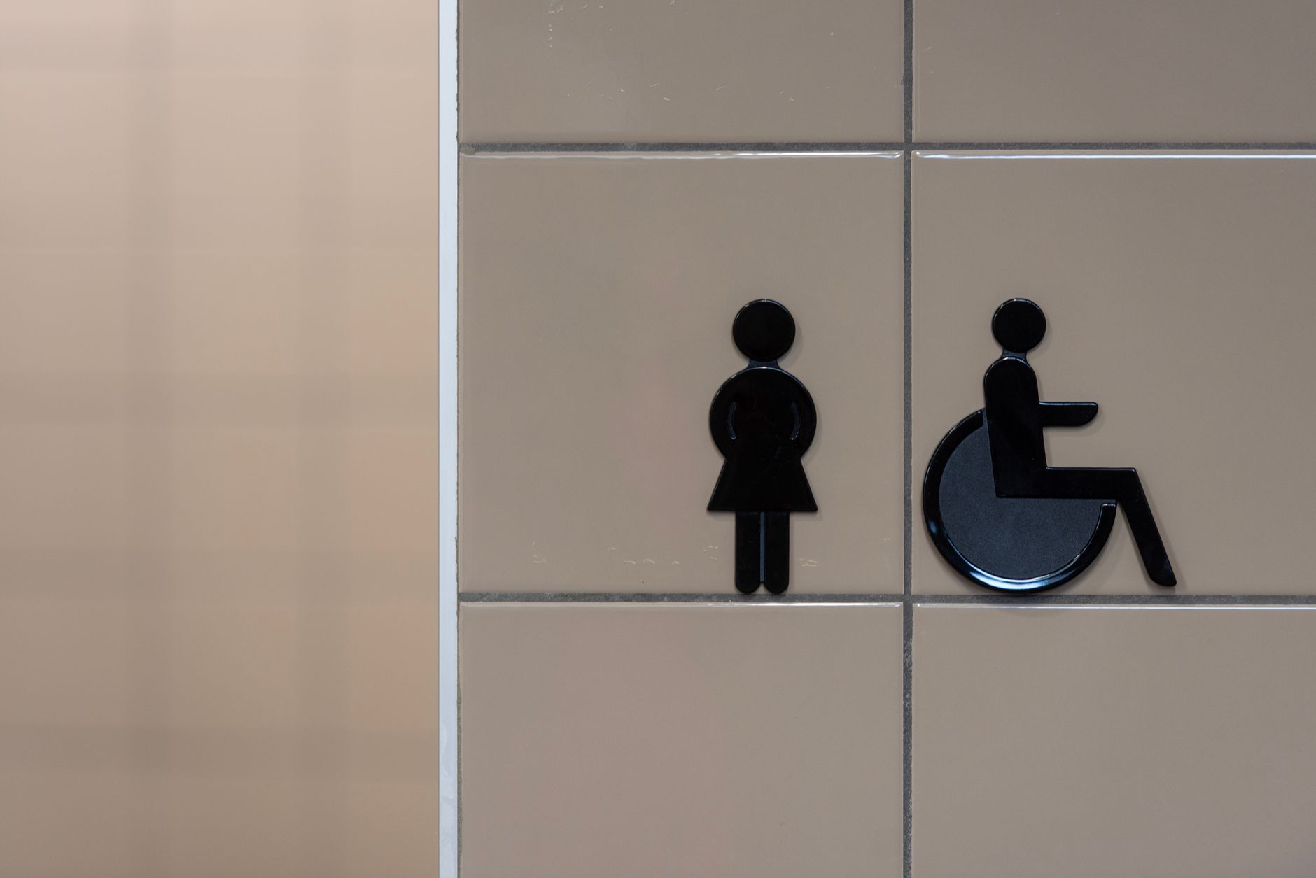 bagni per disabili scuole — Signage showing symbols for an inclusive restroom with wheelchair accessibility.