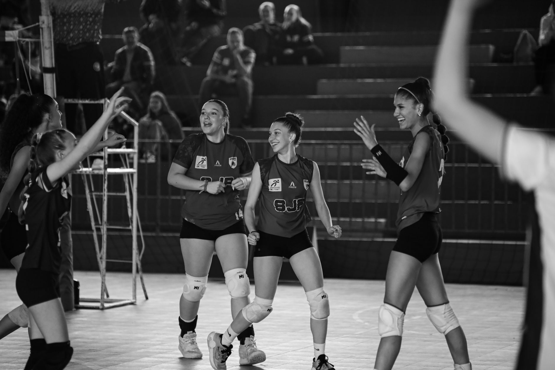 Europei di volley — Black and white photo of a female volleyball team celebrating after a successful game.