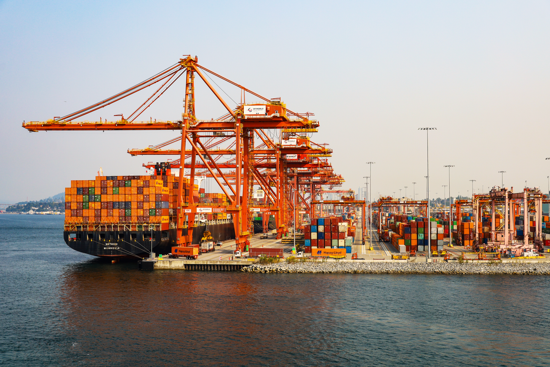 A bustling scene at Vancouver's shipping port showcasing colorful cargo containers and cranes.