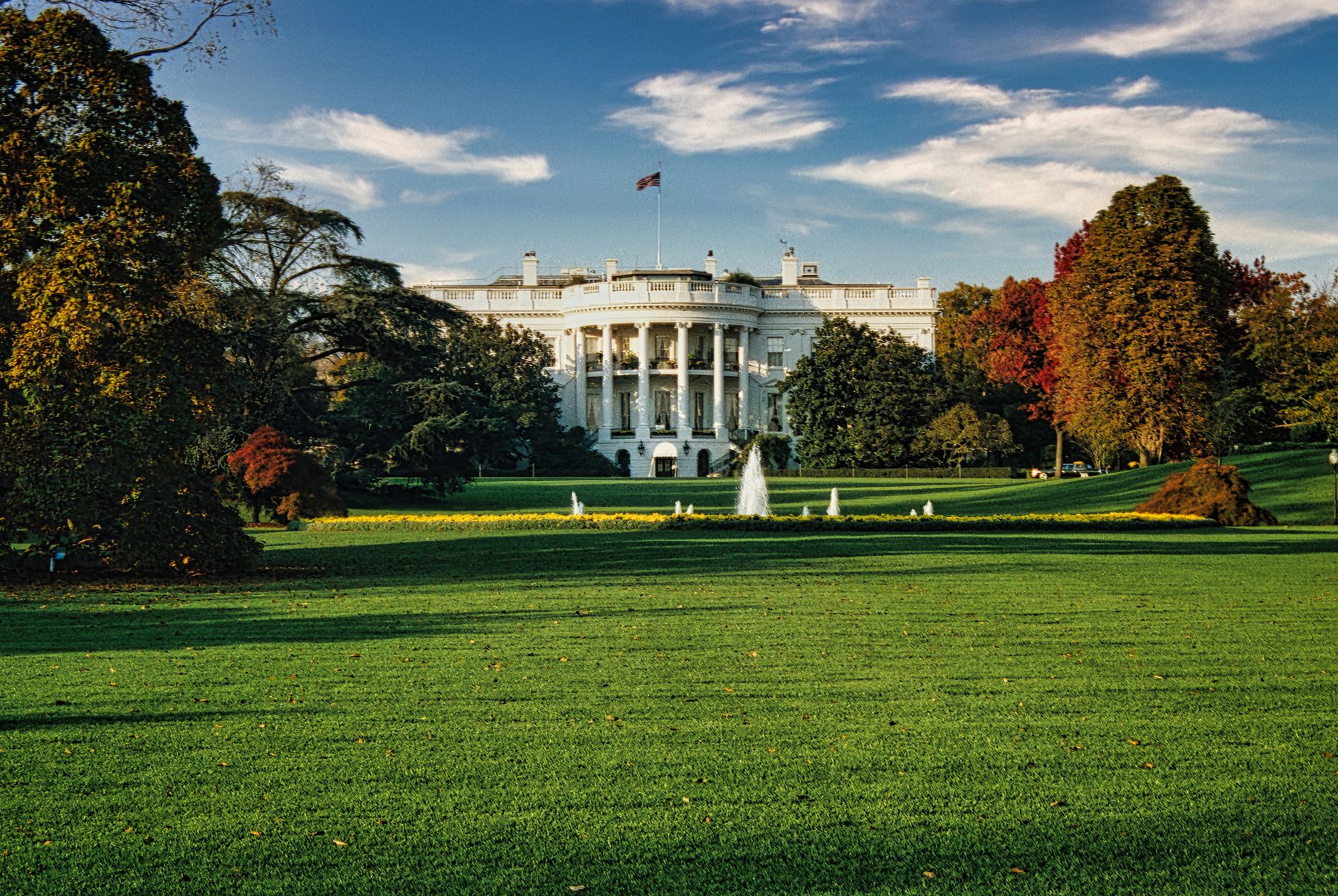 violazione del copyright — A view of the White House surrounded by autumn foliage and a central fountain in Washington, DC.
