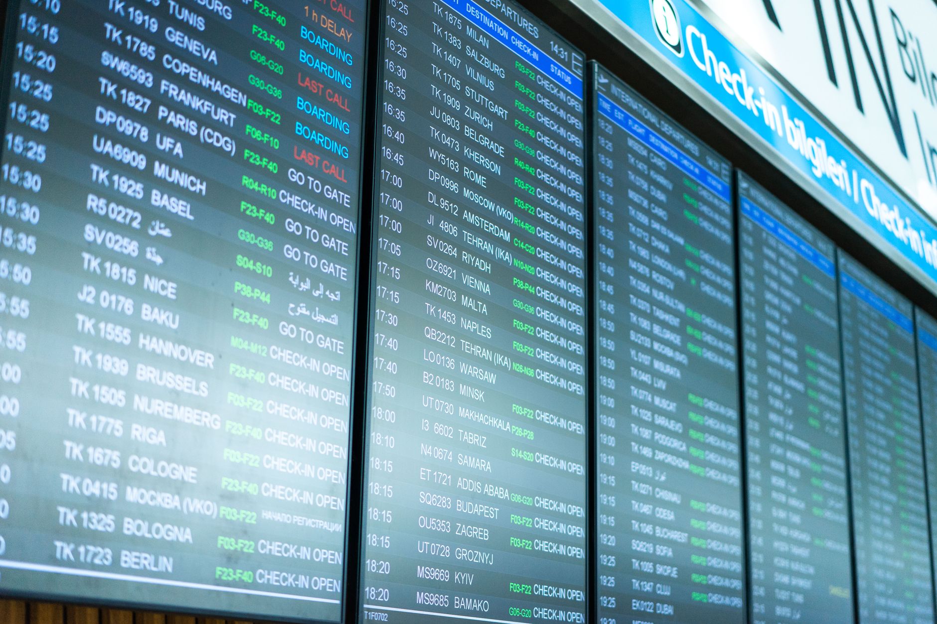 diritti dei passeggeri — Digital screens display flight information and schedules at an airport terminal.