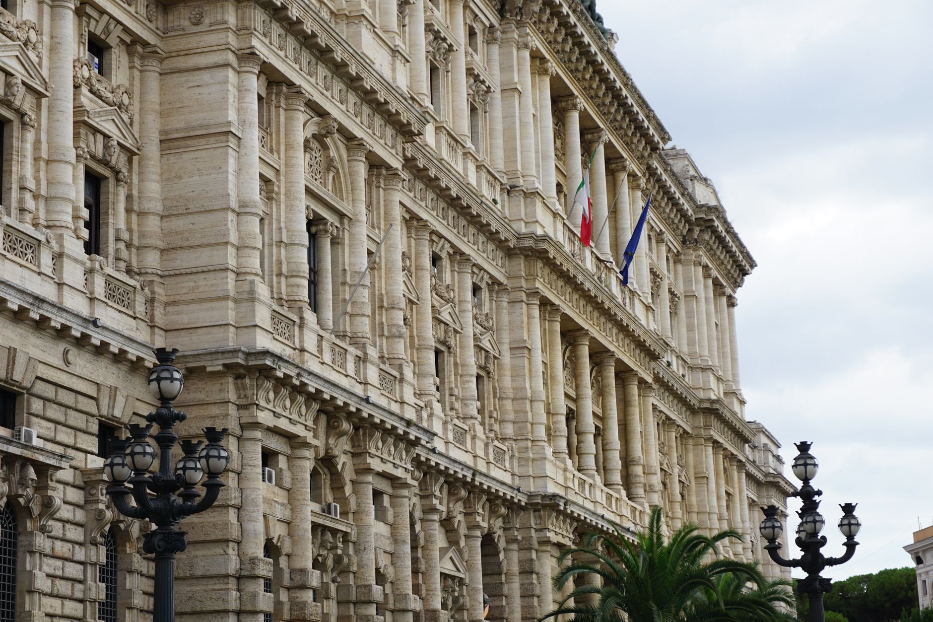 legge elettorale — A captivating view of a neoclassical building facade in Rome with Italian flags and detailed architecture.