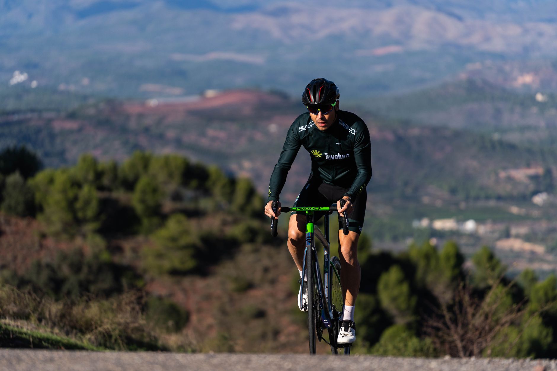 Memorial Pantani — A cyclist wearing sportswear climbing a mountain road amidst a scenic landscape, embodying endurance and adventure.