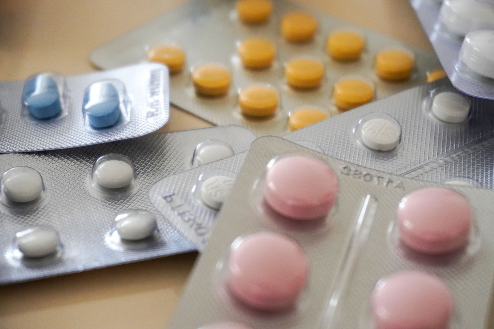 costi farmaceutici sotto brevetto — Close-up view of assorted colorful medication blister packs with diverse pills.