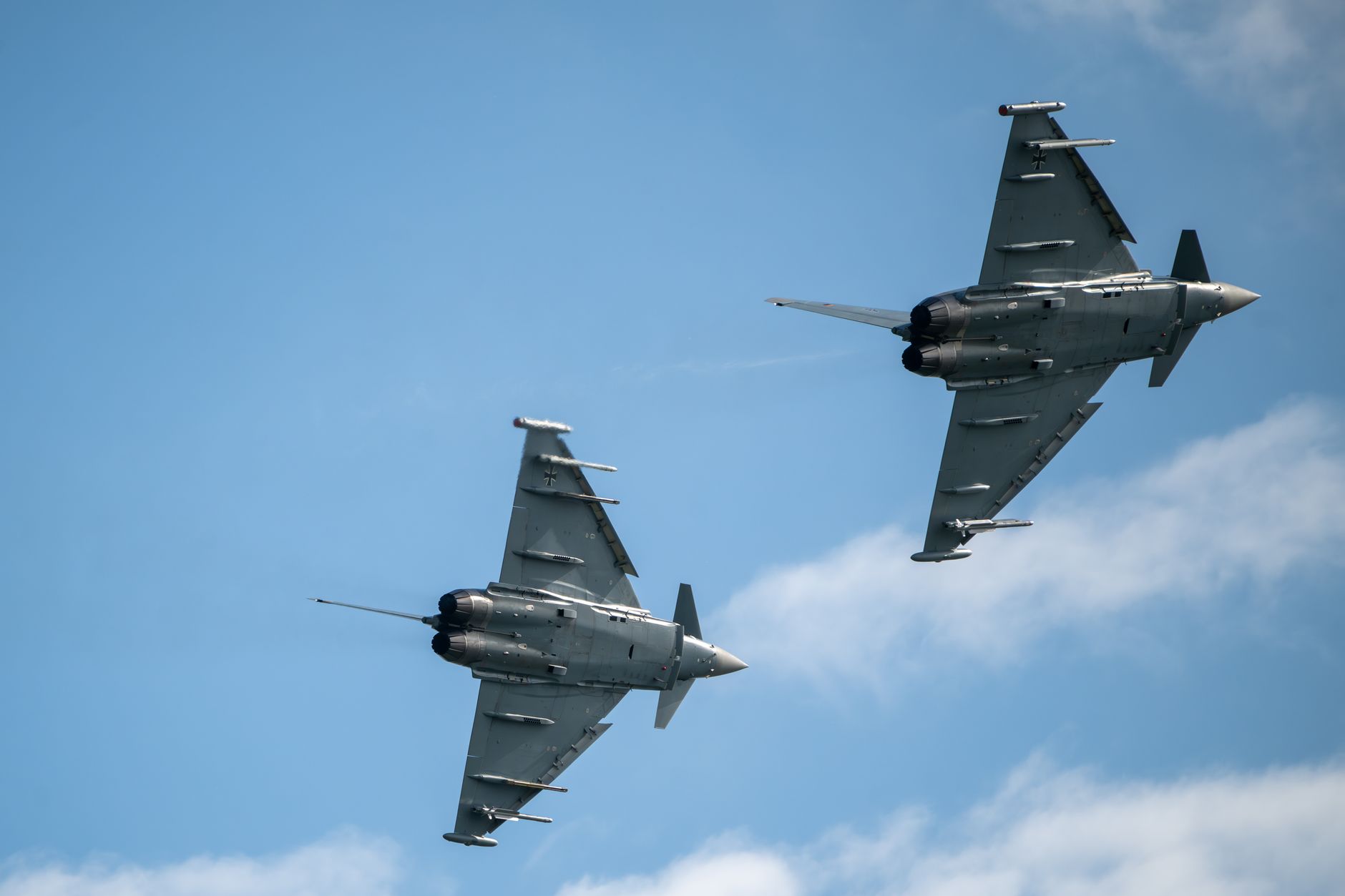violazione spazio aereo polacco — Two Eurofighter Typhoons soaring in formation against a clear blue sky, showcasing military aviation prowess.