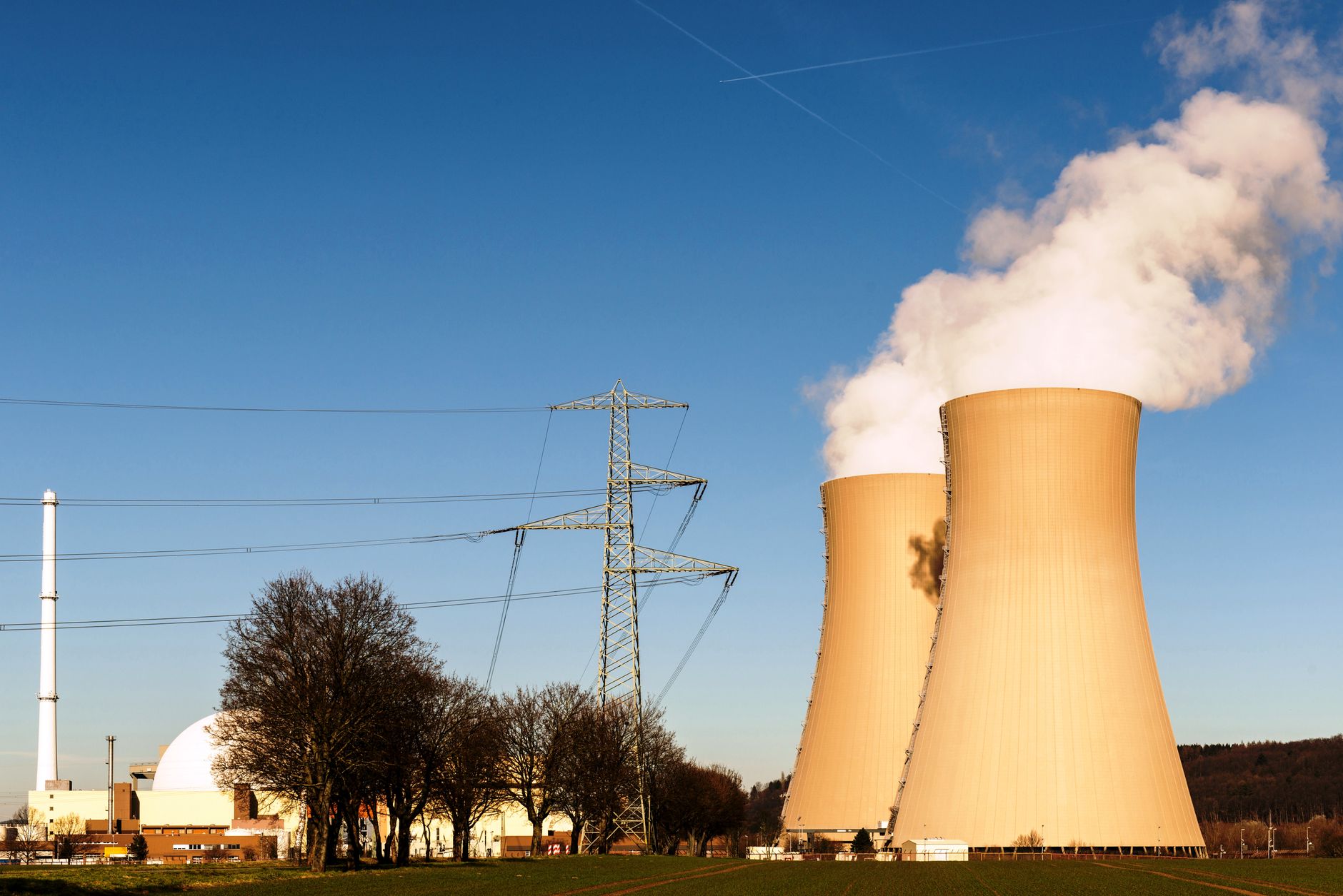 nucleare sostenibile — A nuclear power plant in Hameln, Germany, showcasing cooling towers and electricity pylons.