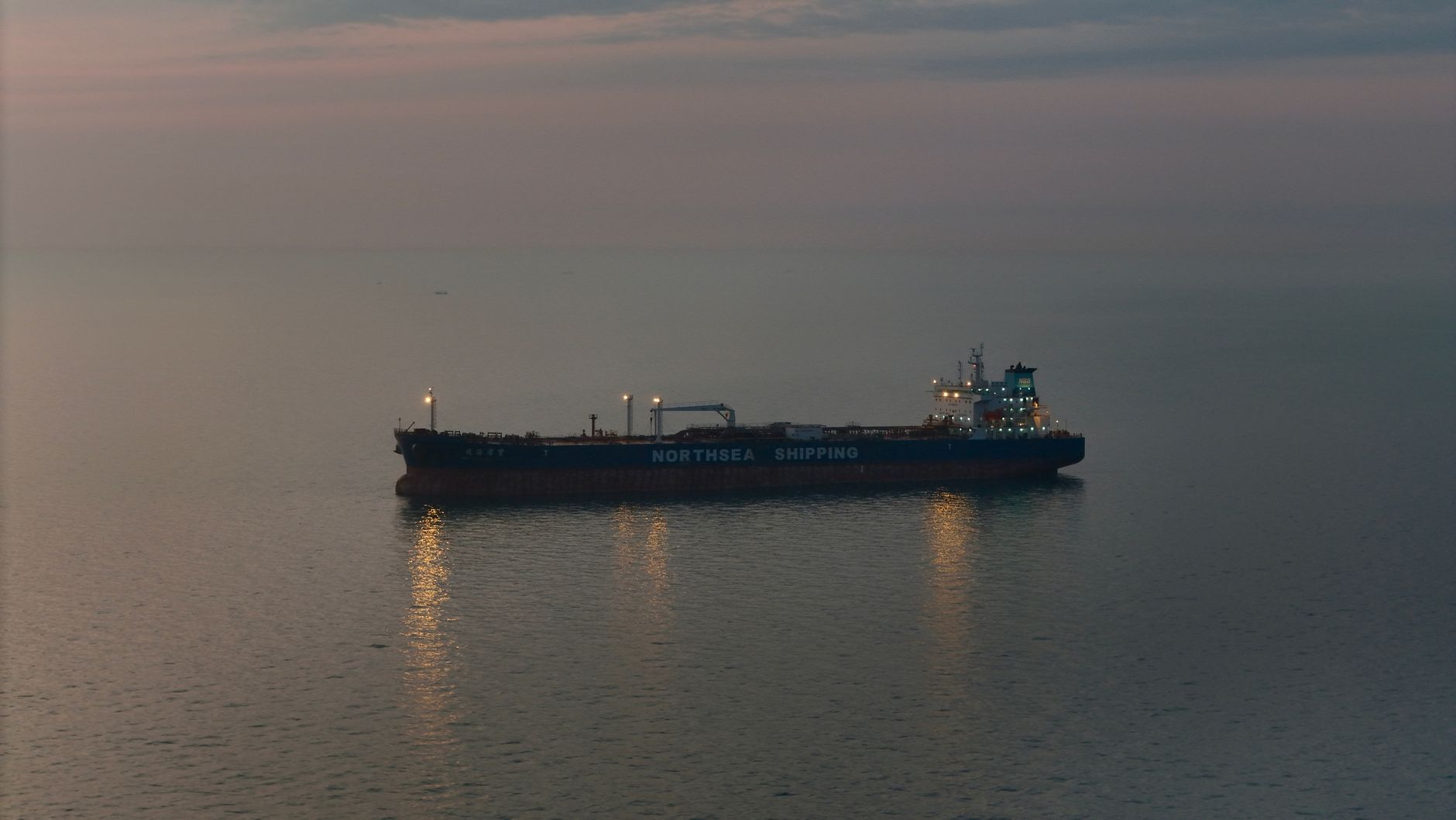 tregua Iran — Oil tanker 'Northsea Shipping' sailing on calm waters during twilight, reflecting a serene scene.